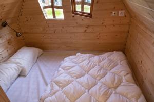 ContyLa cabane magique的木制客房内的一张大白色床