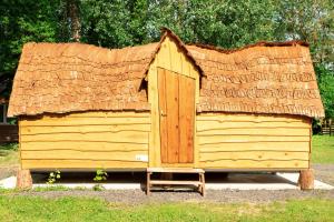 ContyLa cabane magique的茅草屋顶的木制棚屋
