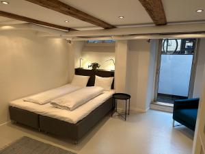 哥本哈根PSG 23 - Short Stay Apartments by Living Suites的卧室配有床、椅子和窗户。
