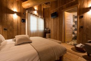 阿亚斯Lavarets Chambres d’Hôtes的卧室配有一张床铺,位于带木墙的房间内