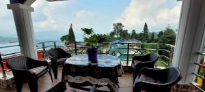 大吉岭Darjeeling View Homestay的美景阳台配有桌椅