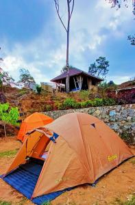 希维德Gunung bangku ciwidey rancabali camp的两个帐篷坐在大楼前的地面