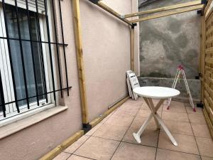 佩皮尼昂Le COSY de Mercadet - Parking gratuit & Wifi的一张小白桌子,坐在窗边的庭院