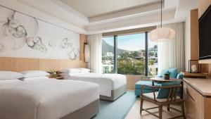 香港香港海洋公园万豪酒店的酒店客房配有两张床和一张桌子及椅子