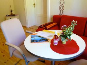 费尔德伯格Ferienwohnung Villa am Haussee的一张带书和鲜花的白色桌子