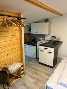 施朗根巴特Tiny Haus Glamping - Natur Park的厨房配有白色橱柜和黑色台面