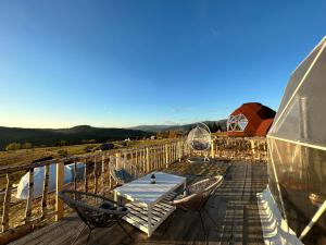 Dorna CîndrenilorDorna Iglu Luxury Glamping Resort的船上甲板上的桌椅