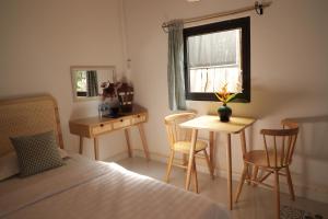 永隆Bình An Village的卧室配有一张床和一张桌子及椅子
