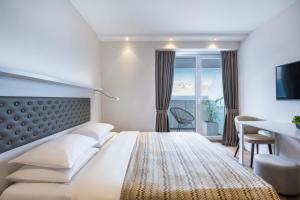 巴统Alliance Palace Batumi的配有一张床、一张书桌和一扇窗户的酒店客房