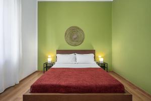 米兰Classbnb - Ampio appartamento a 1km da CityLife的一间卧室配有一张带红色床罩和两盏灯的床。