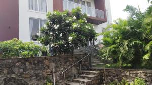 钦奈Mer Vue Villa, Kovalam, ECR, Chennai的前面有楼梯和树木的建筑