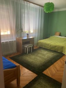 基什孔豪洛什SIESTA vendégház的一间卧室配有一张床、一张桌子和一张桌子