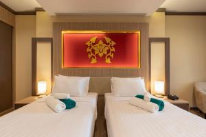芭东海滩Quality Beach Resorts and Spa Patong的墙上画画的房间里设有两张床