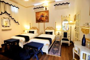 斋浦尔The Royal Hermitage - Best Luxury Boutique Hotel Jaipur的一间卧室设有两张床和一个壁炉