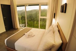 维特利Leaves Resort Vythiri Wayanad的一张位于带大窗户的房间内的床铺