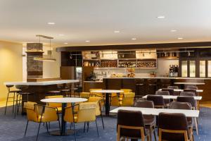 米德尔顿西麦迪逊/米德尔顿万怡酒店的一间带桌椅的餐厅和一间酒吧