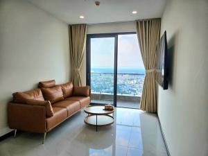 土龙木市C Sky View: 2 BR Apartment Free GYM & POOL的带沙发和大窗户的客厅