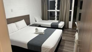 汤斯维尔Townsville City Motel的酒店客房,配有两张床,并备有毛巾