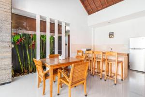 塞米亚克Villa Joylen Seminyak Bali的一间带木桌和椅子的用餐室