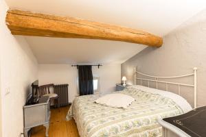 蒙赞巴诺敏西奥庭院住宿加早餐旅馆的一间卧室配有一张木梁床
