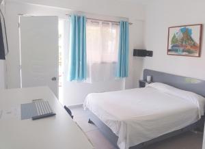 博卡奇卡卡萨可可酒店的一间卧室配有一张床、一张书桌和一个窗户。