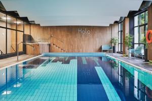 什切尔克Hotel Halo Szczyrk的酒店客房的游泳池铺有蓝色瓷砖