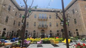 扎赫勒Grand Kadri Hotel - History Marked by Cristal Lebanon的前面有桌椅的建筑