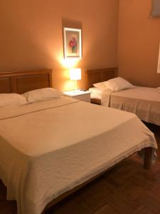 丰沙尔Funchal 19的酒店客房,设有两张床和一盏灯