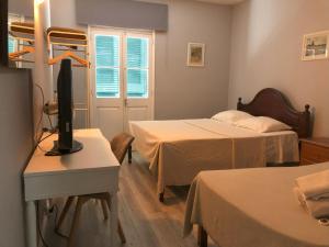丰沙尔Funchal 19的客房设有两张床、一台电视和一张桌子。