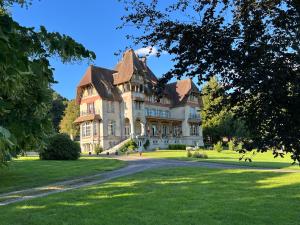 巴尼奥勒德日洛恩Chateau du Gue aux Biches的草地上的大型房子