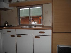 华沙Camping domki letniskowe的一个带水槽和窗户的小厨房
