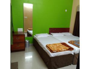 索姆纳特Hotel Shree, Somnath的一间卧室设有一张床和绿色的墙壁