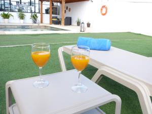 因赫尼奥Villa Alto Arena piscina privada climatizada的两杯橙汁坐在一张白桌旁