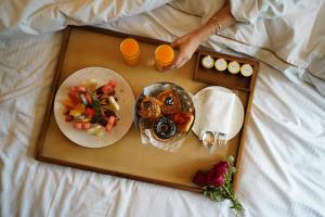 古尔冈The Westin Sohna Resort & Spa的盘子,盘子上放着一盘食物和两杯橙汁