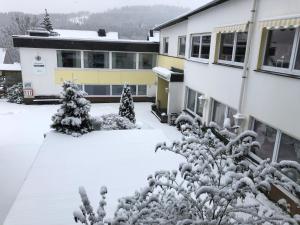 温特贝格Berghotel Natura Bed & Breakfast的建筑物前的雪覆盖的院子