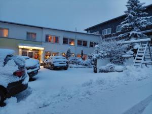 温特贝格Berghotel Natura Bed & Breakfast的大楼前的雪地停车场
