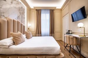 佛罗伦萨Hotel Ungherese Small Luxury Hotel的配有一张床和一张书桌的酒店客房