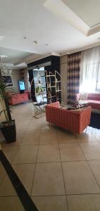 卡索里亚Hotel Daytona Palace的客厅配有红色的沙发和椅子