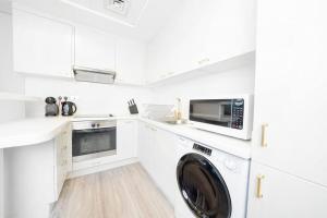迪拜Sky Gardens - Luxury Studio in Central DIFC的白色的厨房配有洗衣机