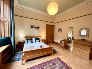 爱丁堡Beautiful Spacious Ground Floor Newington flat的一间卧室配有一张大床和一张桌子