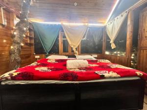 吉布Nebula Nook TreeHouse的一间卧室配有一张带红色毯子的大床