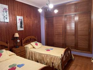 孔苏埃格拉Casa espaciosa con sala de juntas的木墙客房的两张床