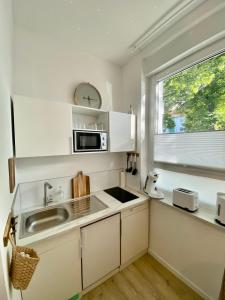 多特蒙德Studio 229的白色的厨房设有水槽和窗户
