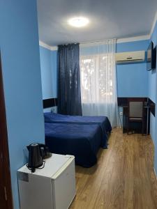 鲁斯塔维奥托帕帕酒店的蓝色卧室配有床、桌子和椅子