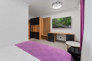 克卢日-纳波卡Fit Residence的一间卧室配有一张床、一张桌子和一张桌子