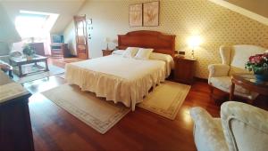 巴利亚多利德Hotel Conde Ansúrez的一间卧室配有一张大床和两把椅子