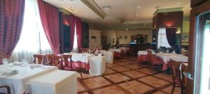 巴利亚多利德Hotel Conde Ansúrez的用餐室配有白色的桌子和红色的椅子