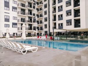 迪拜Nasma Luxury Stays - Home-Style 2BR Apartment with a Balcony View的一座带躺椅的游泳池和一座建筑