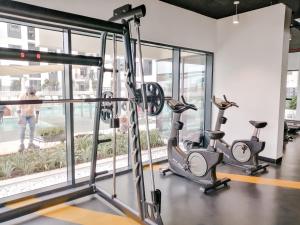 迪拜Nasma Luxury Stays - Home-Style 2BR Apartment with a Balcony View的窗户前设有跑步机和椭圆机的健身房
