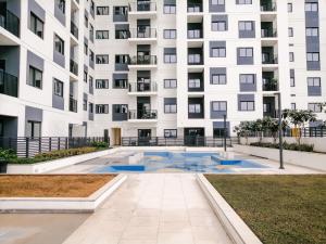 迪拜Nasma Luxury Stays - Home-Style 2BR Apartment with a Balcony View的公寓大楼前方设有游泳池